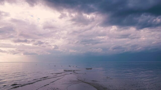 Evening on the Baltic Sea at the end of summer. Waves meet each other on the shallows. Birds sway on the waves of the coast of the Gulf of Riga. Baltica, Latvia