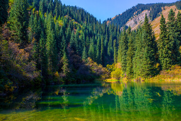 Lake Kaindy sunken forest in Kazakhstan. Beautiful mountain nature landscape. Blue lake Kolsai top view. Panoramic view of the nature reserve.