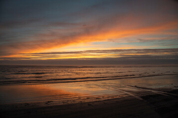 Fototapeta na wymiar Sunset beach waves and clouds