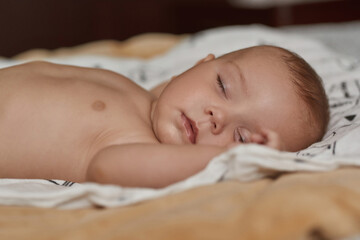 Restful baby peacefully sleeping in soft and cosy bed
