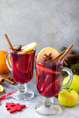 Christmas mulled wine, winter alcoholic drink. Two glass of mulled wine (gluhwein) and its ingredients on a stone background. Copy space.
