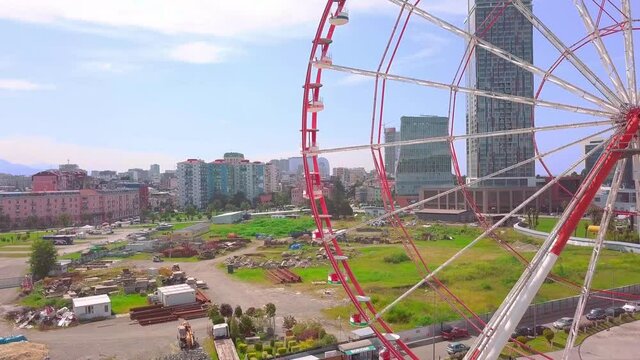 Drone footage. Aerial photography of a drone flying around a Ferris wheel on the seashore of the city of Batumi, Georgia, Adjara. The drone flies over the statues of Ali and Nino in love.