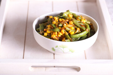 salad with corn green beans and onions is on the table