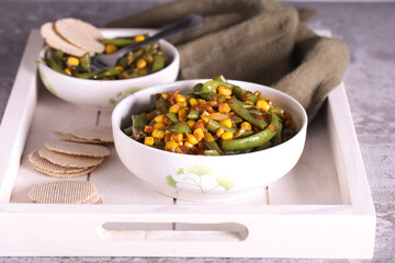 salad with corn green beans and onions is on the table