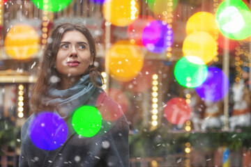 Dreaming lady walking with bokeh light during the snowfall