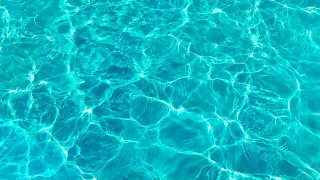 Water surface texture, Slow motion clean swimming pool ripples and wave, Refraction of sunlight top view texture sea side white sand, sun shine water background. Water Caustic Background.