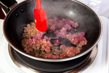 Preparation of the traditional Colombian hogao or criollo sauce (salsa criolla) made of onion, tomato, peppers and cilantro