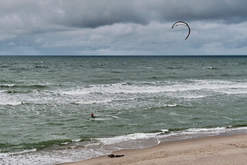 Beautiful seascape with kitesurfer, riding waves.