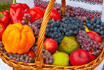 Apples, pears, grapes and peppers in a basket. Vegetables close up. Picnic food.