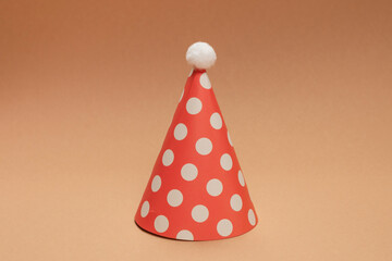 Colorful birthday cap on brown  background.