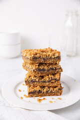 Date squares (or Matrimonial cake) stacked on a plate in a white kitchen