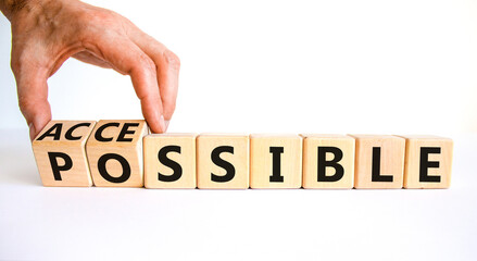 Possible and accessible symbol. Businessman turns wooden cubes and changes the word possible to accessible. Business and possible or accessible concept. Beautiful white background, copy space.