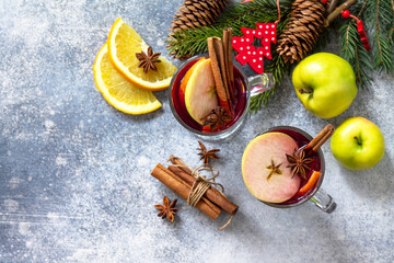 Christmas mulled wine, winter alcoholic drink. Two glass of mulled wine (gluhwein) and its ingredients on a stone background. Top view flat lay background. Copy space.