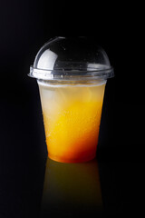 Fresh cold tasty cocktail with orange juice, lemonade, with ice isolated on a black background