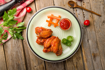 chicken wings in barbecue sauce with tomato sauce top view on wooden table