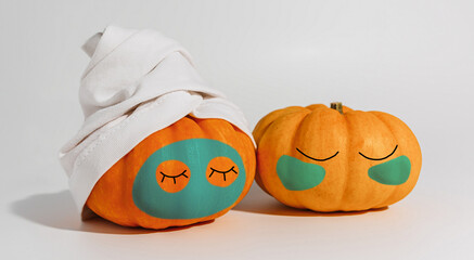 Pumpkin with facial mask and towel isolated on white background. Space for text mockup spa and Halloween concept