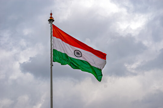 Indian National Flag , flying high in the sky on a cloudy background.