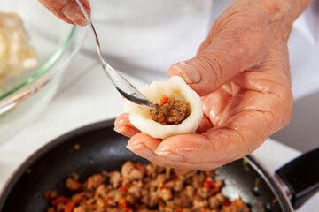 Preparation of a traditional Colombian fried  stuffed yucca dumplings called carimañolas