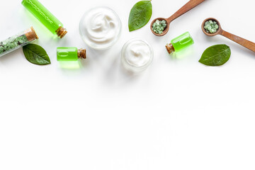 Tea tree cosmetics with essential oil and green leaves