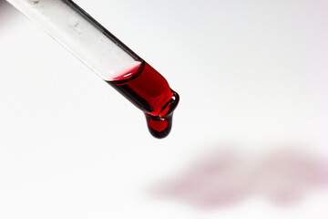 pipette with wine drops on white sheet with stains