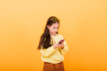 Cute little girl wearing bright stylish clothes on yellow colorful background