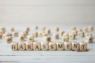 Word HARASSMENT written on wooden cubes. Sexual absuse and violence concept