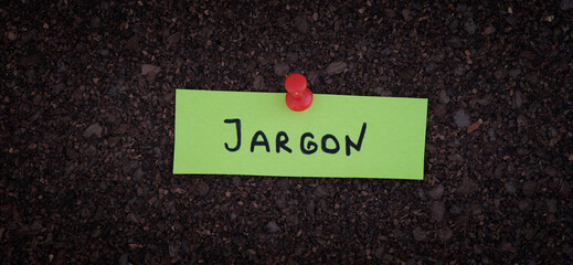 A sticky note with the word Jargon on it pinned to a cork board.