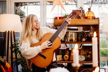 Obraz premium young woman play the guitar. learning to play musical instruments.