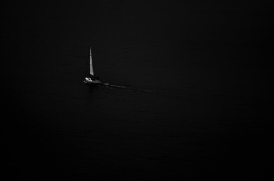 Einsames Segelboot auf dem Atlantik vor spanischer K&uuml;ste in Schwarz/Wei&szlig;