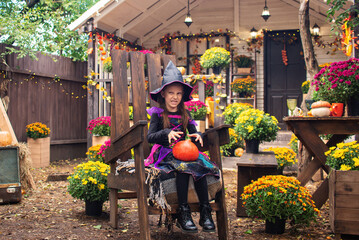 Fototapeta na wymiar happy child girl wearing witch costumes in autumn halloween holiday