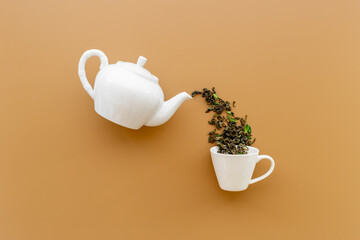 Tea background o white teapot and cup with dry tea leaves