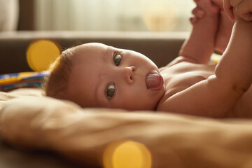 Expressive adorable baby infant showing tiny tongue