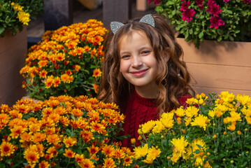 autumn portrait of a little cute girl with chrysanthemums