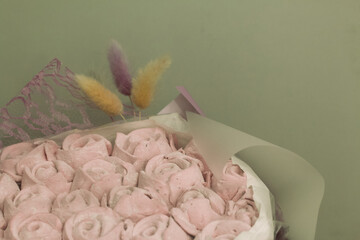 Fototapeta na wymiar Marshmallow bouquet packed in craft paper. Zephyr rose flowers.