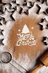 Merry christmas inscription made of flour on a wooden table.