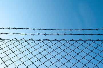 Barbed wire facing the blue sky