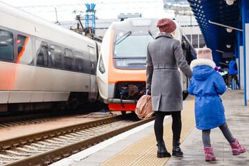 passengers in the subway station. mother daughter train station