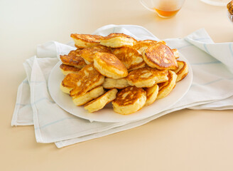 Freshly baked pancakes in a white plate on the table. Delicious morning breakfast with hot pancakes. homemade delicious fried