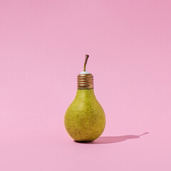 Creative composition of pear light bulb on pastel pink background. Innovation, idea and creativity concept. Minimal aesthetic design.