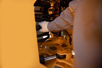 Professional mechanic checks hydraulic hose system equipment on excavator to raise bucket