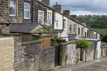 A steep terrace of traditional 19th century millworkers' cottages, seen from the back lane between Basil Street and Colne Lane: Colne, Lancashire, UK