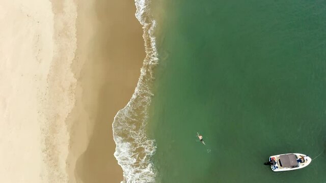 Imagem a&eacute;rea homem nadando na praia