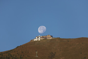 Bergstation und untergehender Mond.