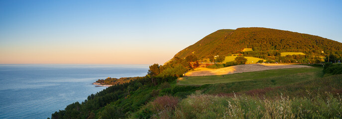 Sunset landscape Conero natural park dramatic coast headland rocky cliff adriatic sea beautiful sky...