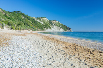 The beach of Mezzavalle unique bay in Conero natural park dramatic coast headland rock cliff...