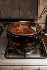 Preparing chocolate sauce in a pot in the kitchen for the preparation of the homemade Argentine alfajores recipe