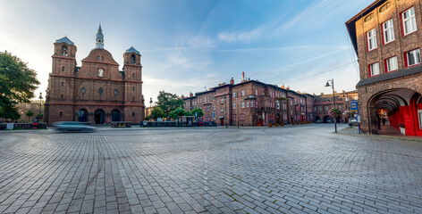 Katowice, Silesia, Poland; September 29, 2021: View on central square (plac Wyzwolenia) in historical district Nikiszowiec in the morning. S. Anna's Church in the background. Old, brick buildings.