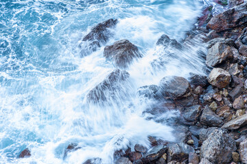 High angle view of waves crashing on rocks.