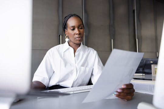 Businesswoman reviewing paperwork at office desk