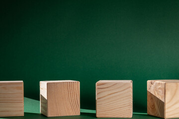 wooden cubes still life against emerald green background